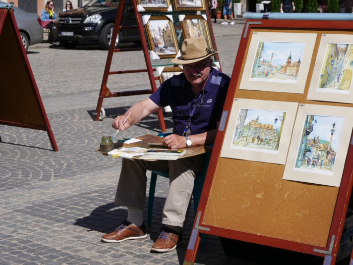 An artist painting in the Old Town Square, Warsaw