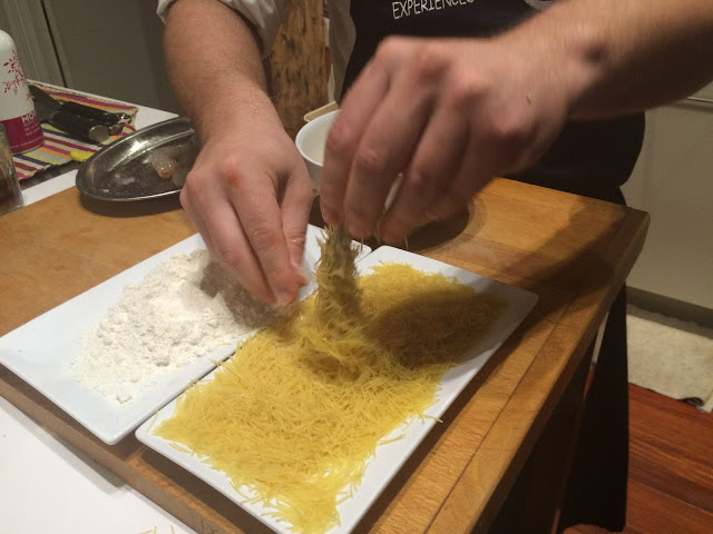 Covering the prawns in angel hair pasta - Tenedor tours cooking class - San Sebastian